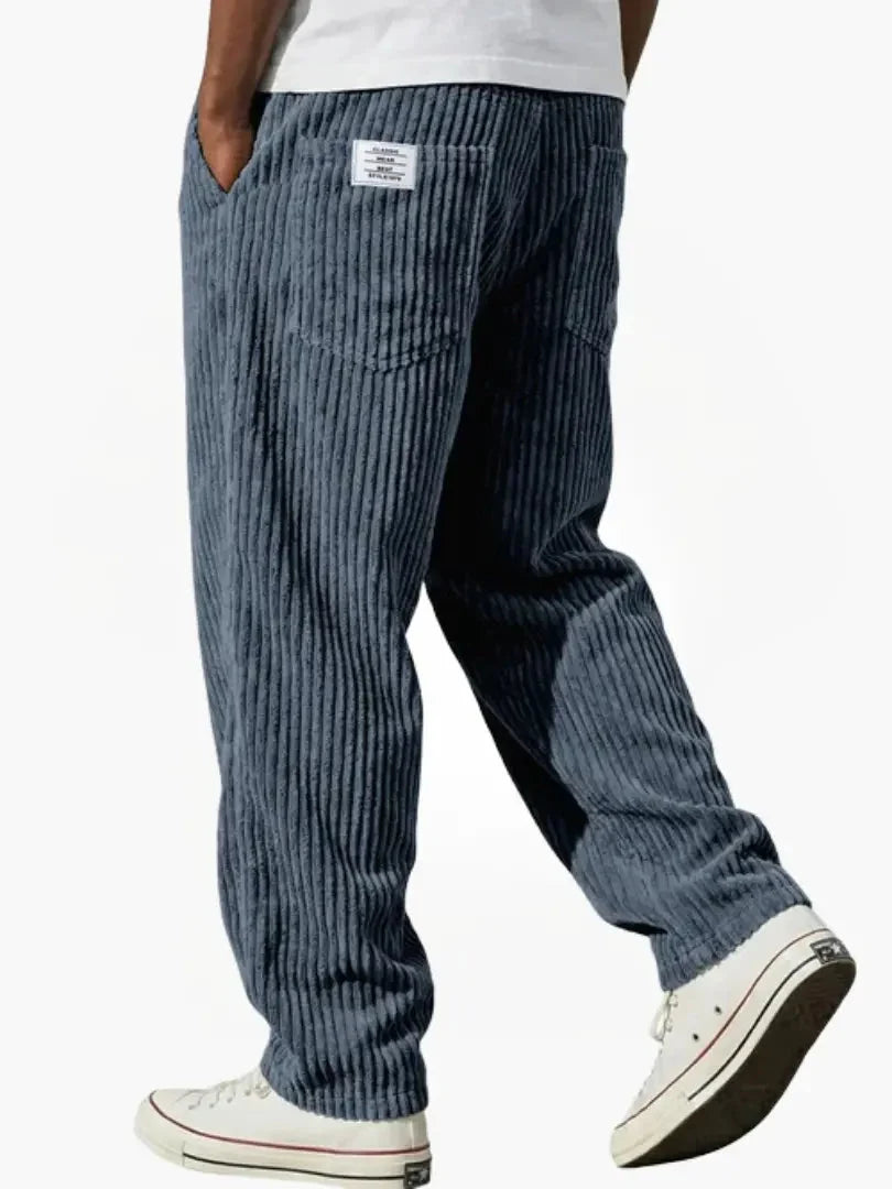 Side view of relaxed fit corduroy trousers with structured fabric drape and functional pocket detailing