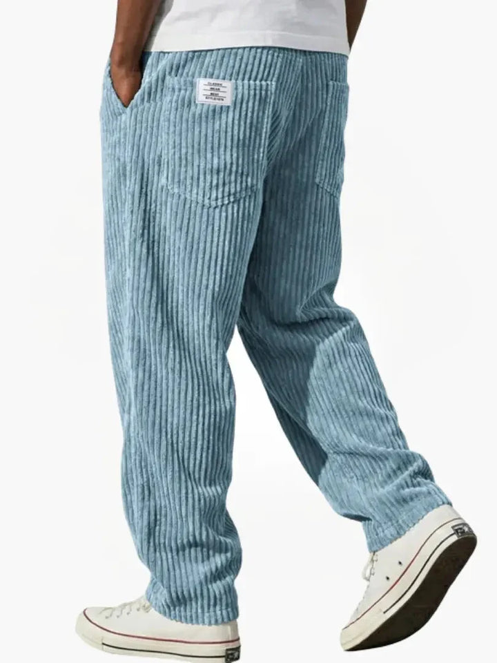 Detail shot of corduroy trousers waistband featuring small patch label and drawstring closure