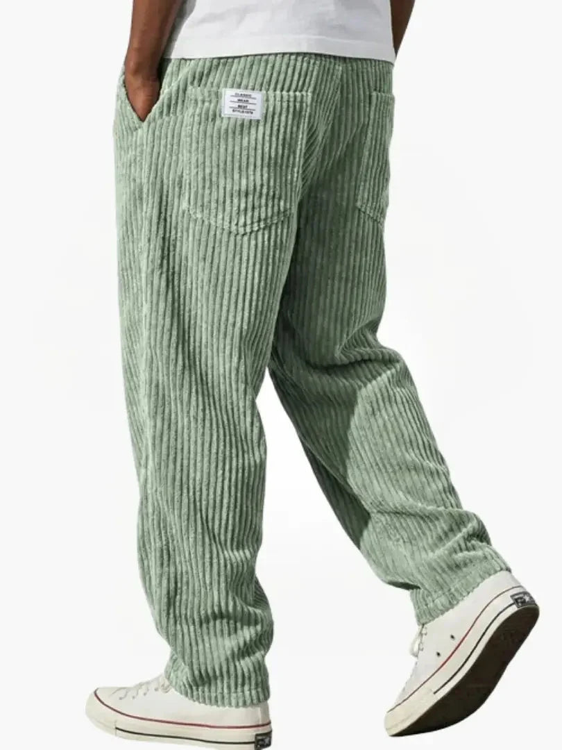 Men's ribbed corduroy trousers in grey showing relaxed fit through the leg