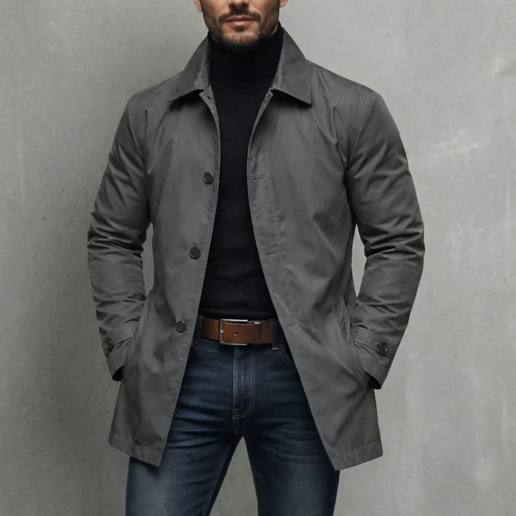 Men's grey fly front coat with relaxed fit and notched collar, styled over black turtleneck