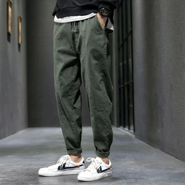 Side view of men's tapered joggers featuring elasticated waistband and practical side pockets