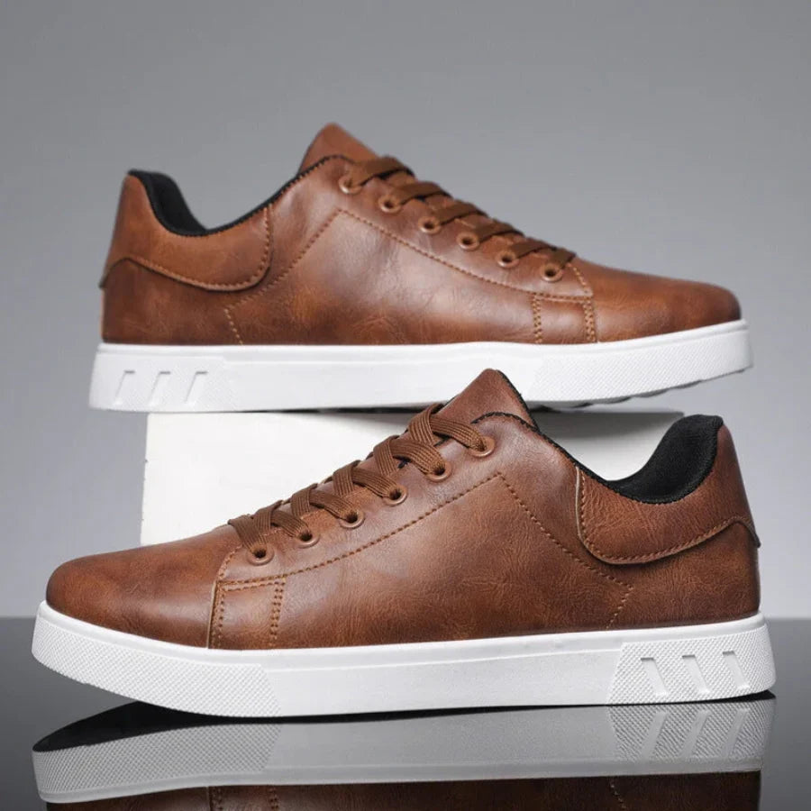 Detail of men's low-top trainers showing stitching and structured finish on synthetic material
