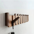 Close-up view of piano-inspired wooden coat rack showing alternating beech and walnut wood hook arrangement