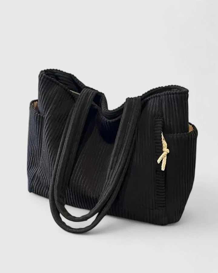Close-up view of olive corduroy tote bag showing ribbed texture and structured shape