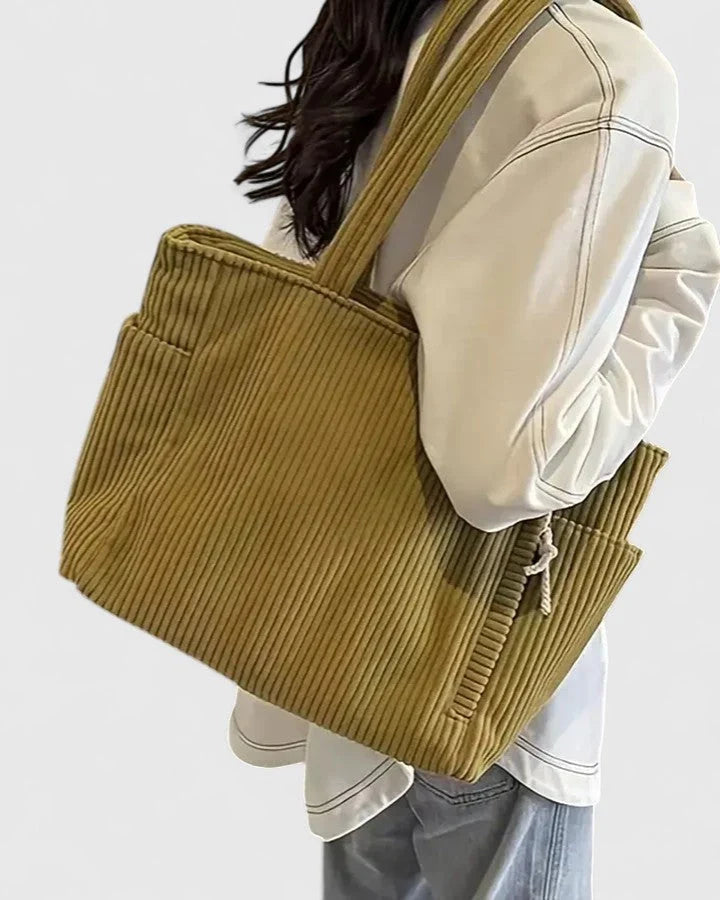 Model holding structured corduroy tote bag showcasing everyday carryall design