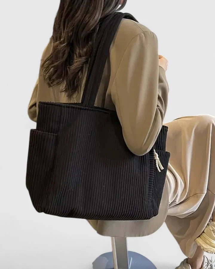 Detail shot of corduroy tote bag exterior pocket and contrast rope accent