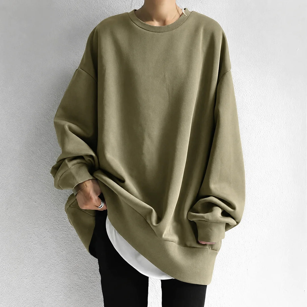 Close-up view of women's oversized sweatshirt showing relaxed fit and tunic length with ribbed cuffs