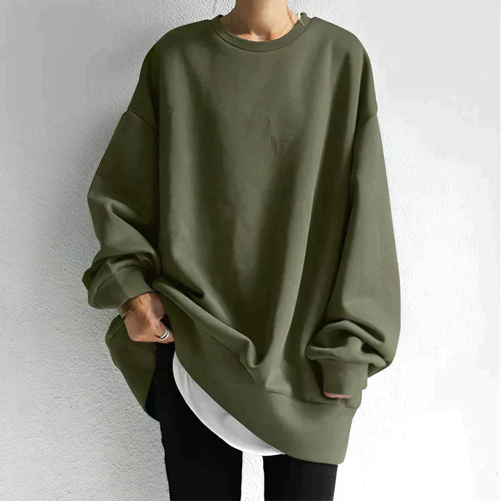 Side angle of women's black oversized sweatshirt featuring drop shoulders and extended hem coverage