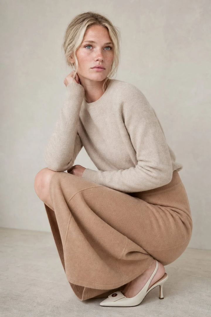 Side angle of high-waist wool skirt displaying flowing A-line silhouette and midi length hem