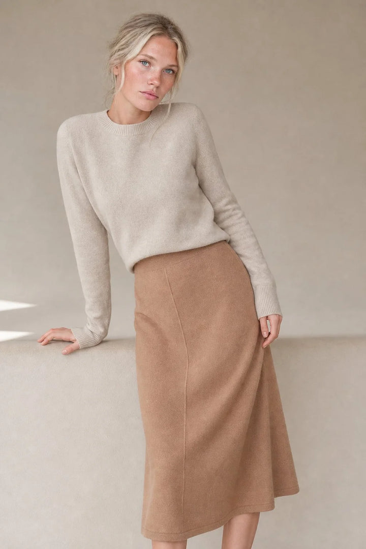 Model seated showing relaxed fit of knit wool skirt with comfortable elasticated waistband detail