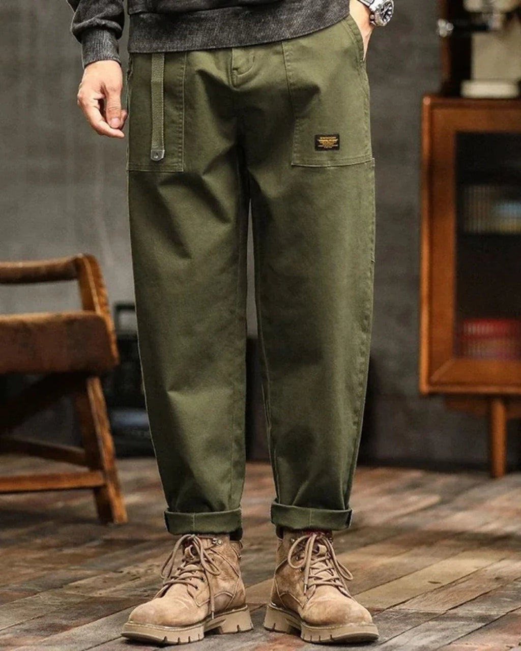 Men's cargo trousers in olive green with relaxed fit and flap pockets worn with boots
