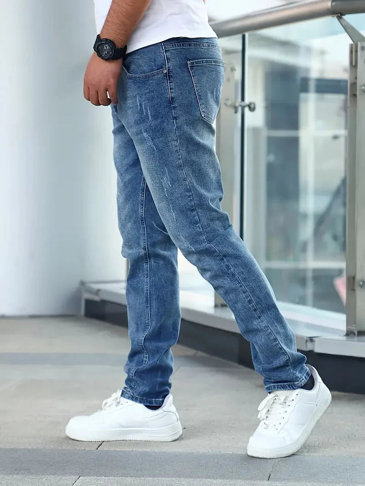 Rear view of men's jeans showing back pockets with contrast stitching and slim fit silhouette