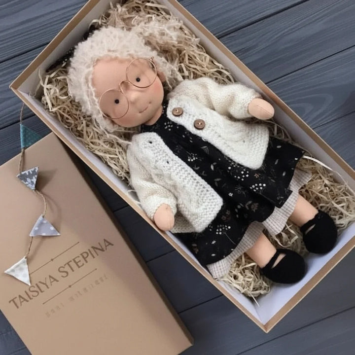 Handcrafted cloth doll with minimalist design and coordinating knitted garments