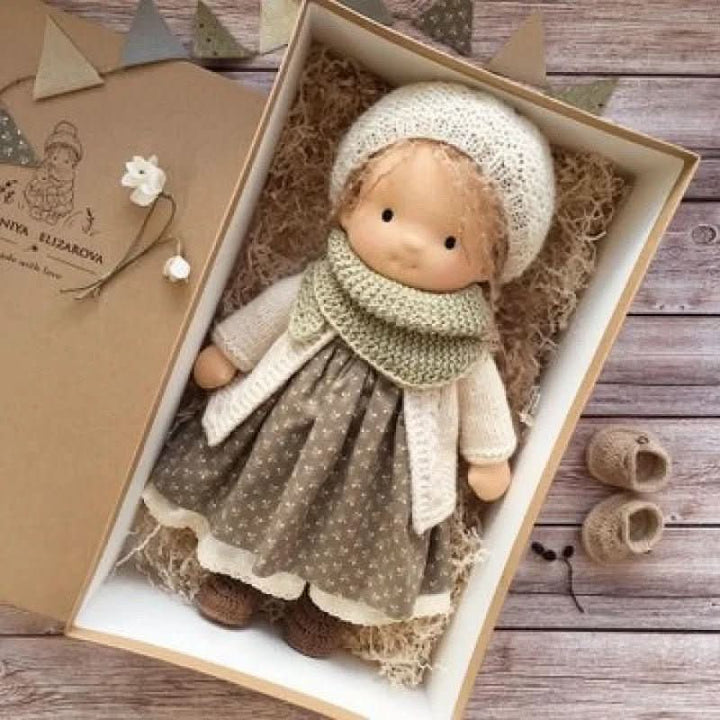 Cloth doll with knitted bonnet and cardigan encouraging creative storytelling