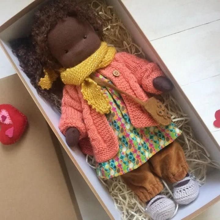 Waldorf-style doll dressed in coordinating outfit with lace-trimmed dress and booties