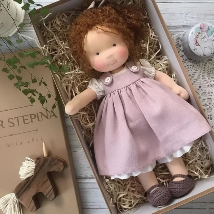 Cloth doll in gift presentation box showing cream and lilac colour palette