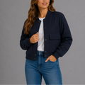 Women's bomber jacket in navy with ribbed collar and button-front closure worn with jeans