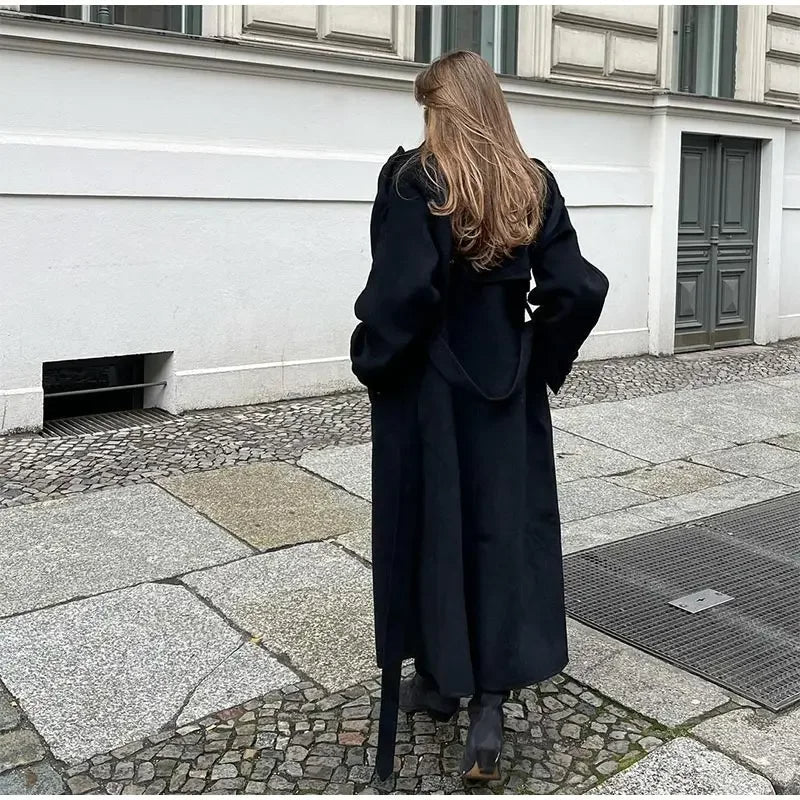 Women's black trench coat showing button-front closure and relaxed fit through body