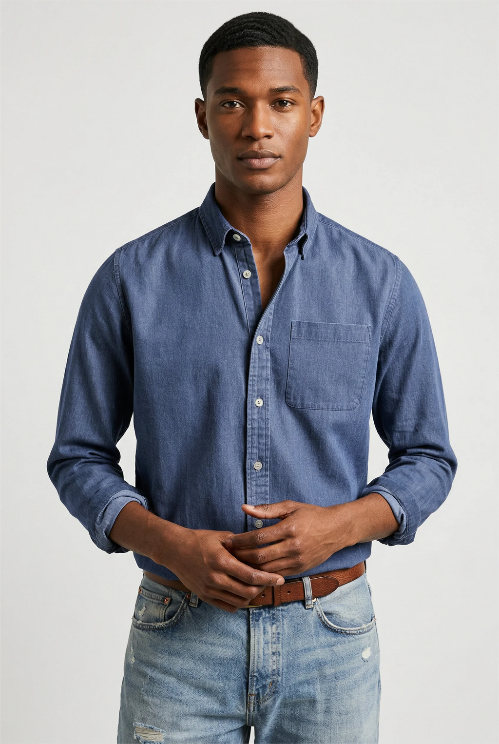 Men's long sleeve denim shirt in mid-blue with button-up front and chest pocket, relaxed fit for casual wear