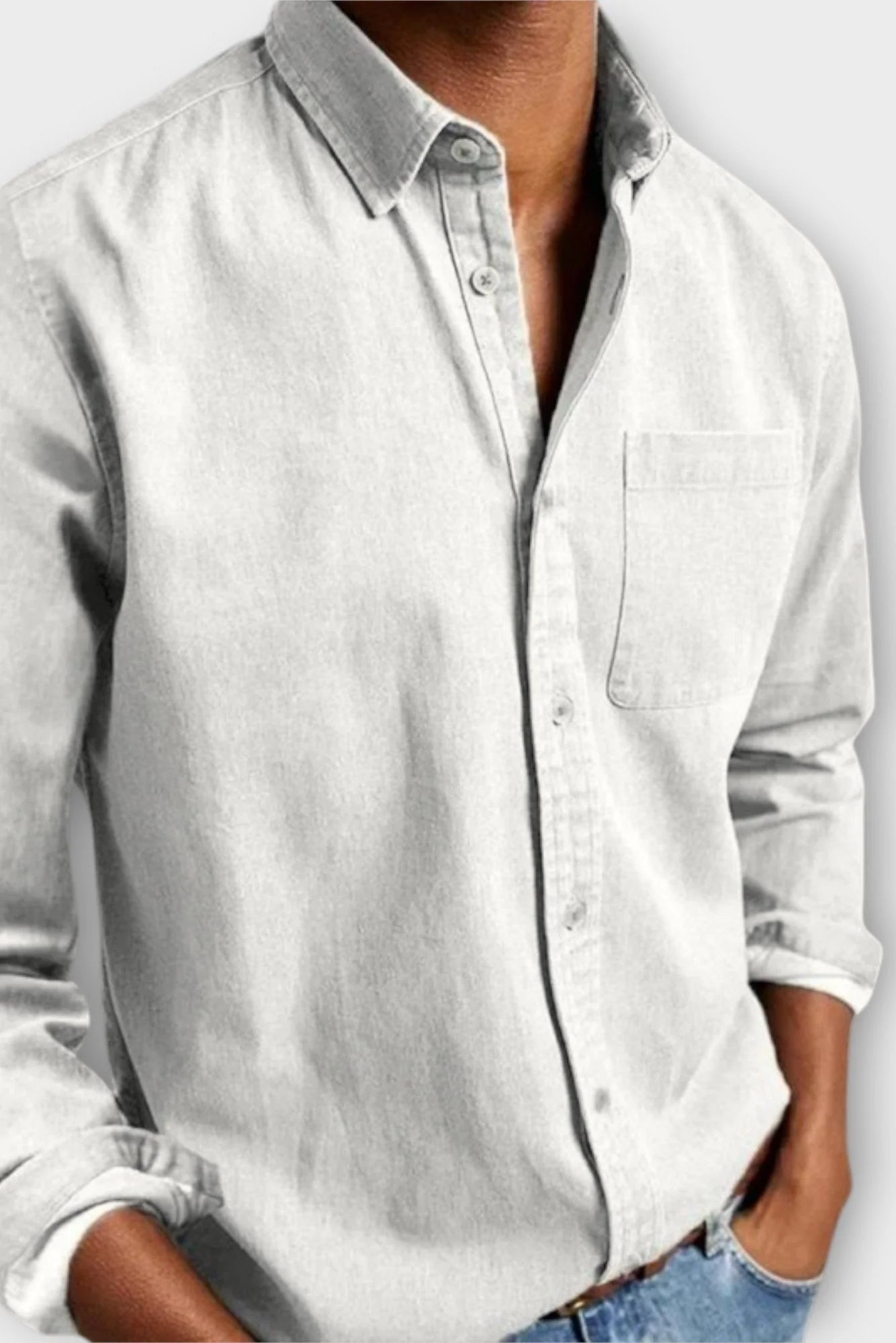 Close-up of men's denim shirt cuff with adjustable button closure, long sleeve design
