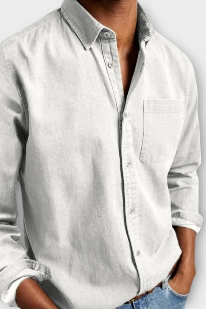 Close-up of men's denim shirt cuff with adjustable button closure, long sleeve design