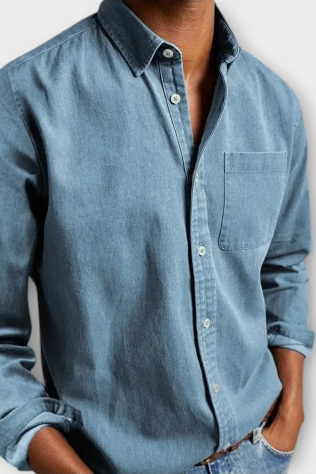 Full-length view of men's denim shirt with long sleeves, button-up front, and chest pocket detail