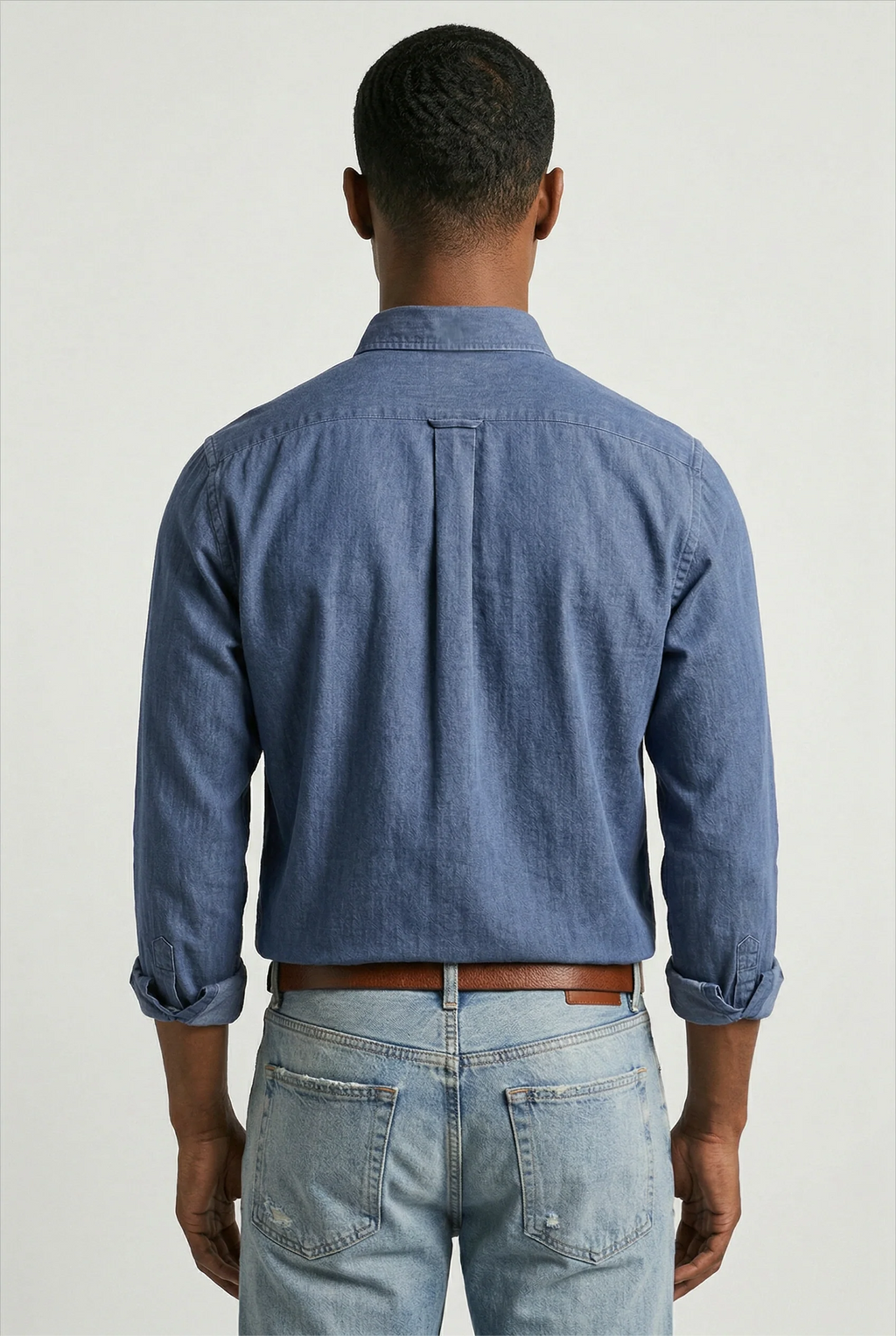 Close-up view of men's denim shirt showing woven fabric texture and structured collar detail