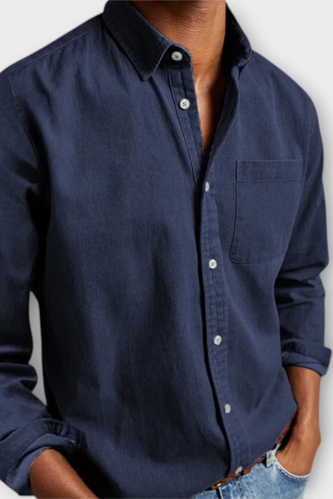 Detail shot of men's denim shirt chest pocket and button placket, functional design for everyday use