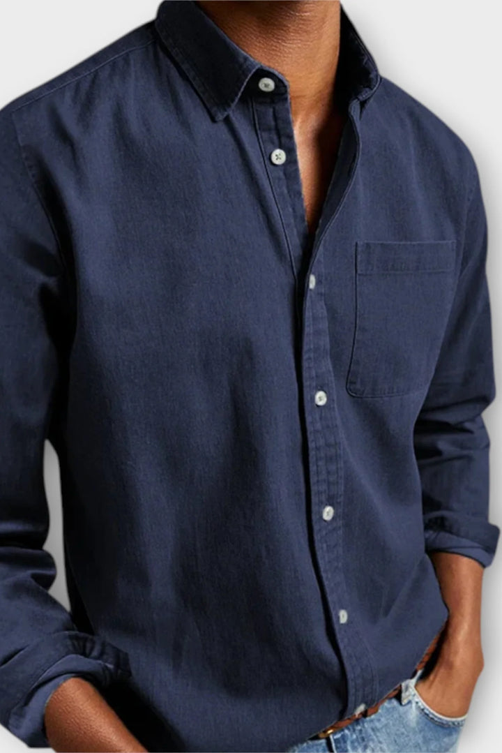 Detail shot of men's denim shirt chest pocket and button placket, functional design for everyday use