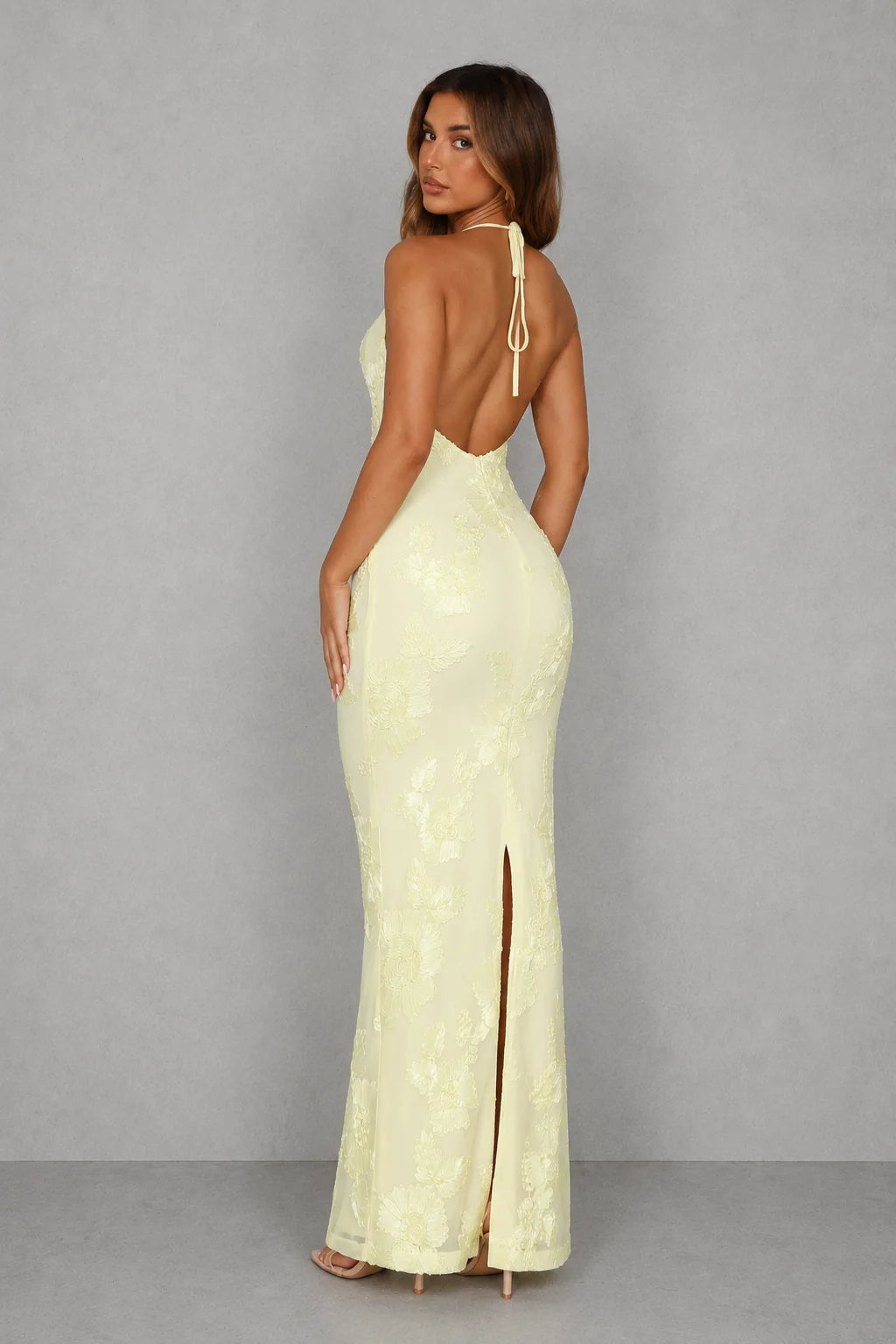 Close-up of halter neckline and embroidered floral detailing on fitted bodice of formal maxi dress