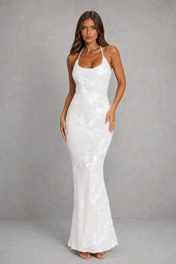 Model wearing halter backless maxi dress styled with strappy heels for formal evening reception