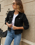 Women's cropped denim jacket in black with classic collar and chest pockets styled over white tee