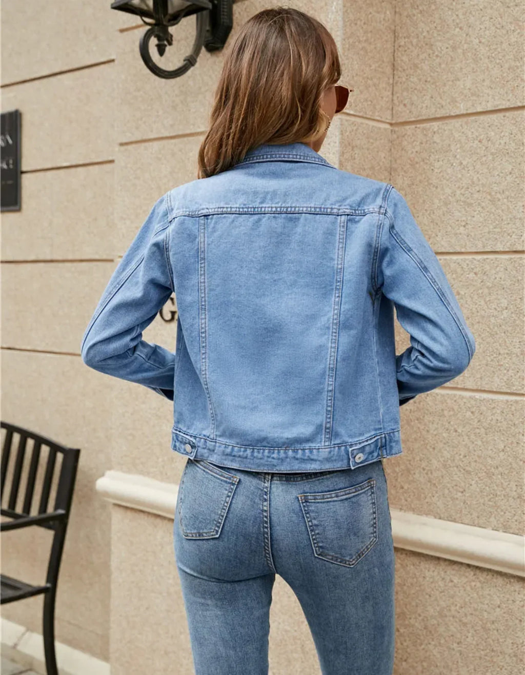 Rear view of cropped denim jacket highlighting structured shoulders and clean back panel