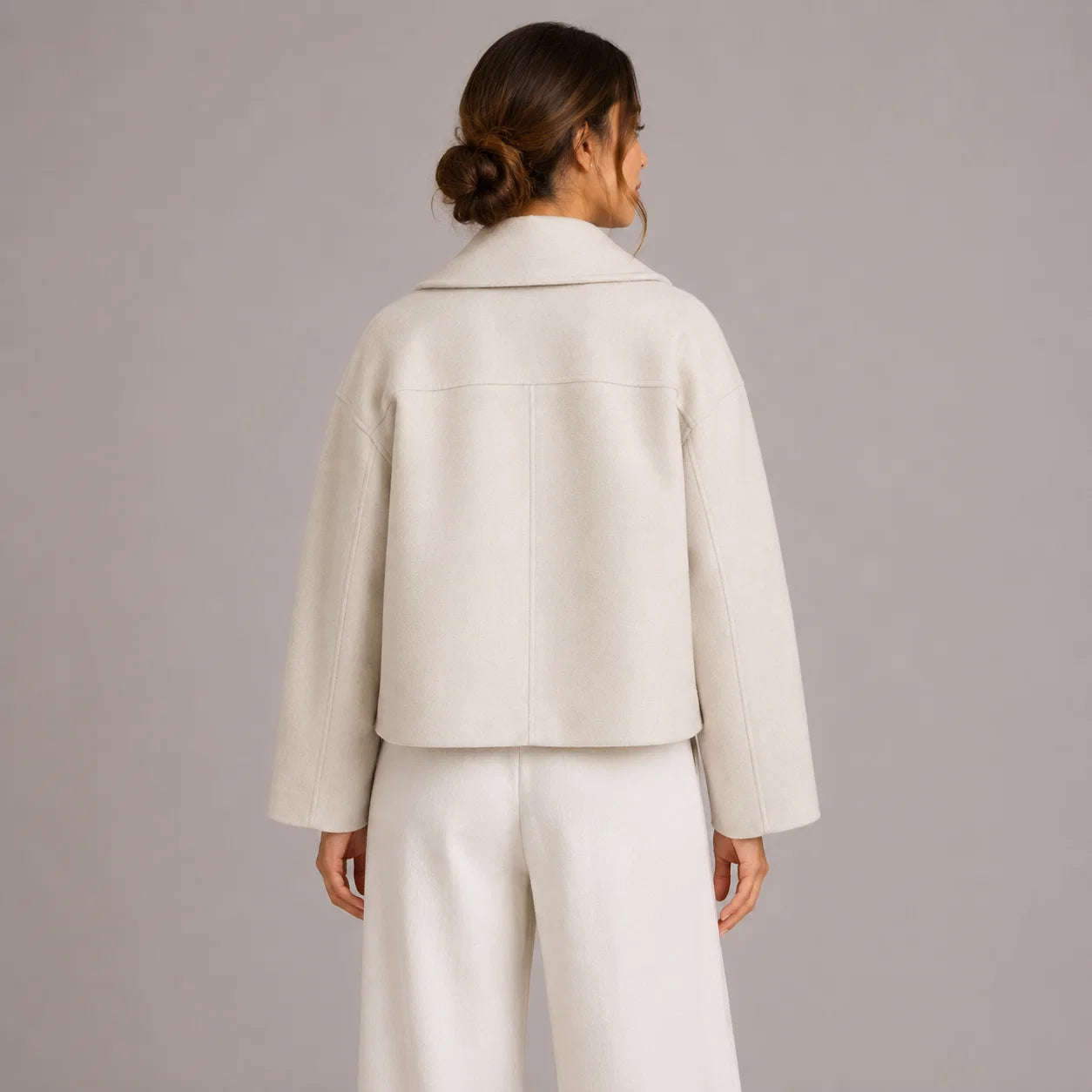 Close-up of women's tailored blazer showing structured fabric and decorative button detail