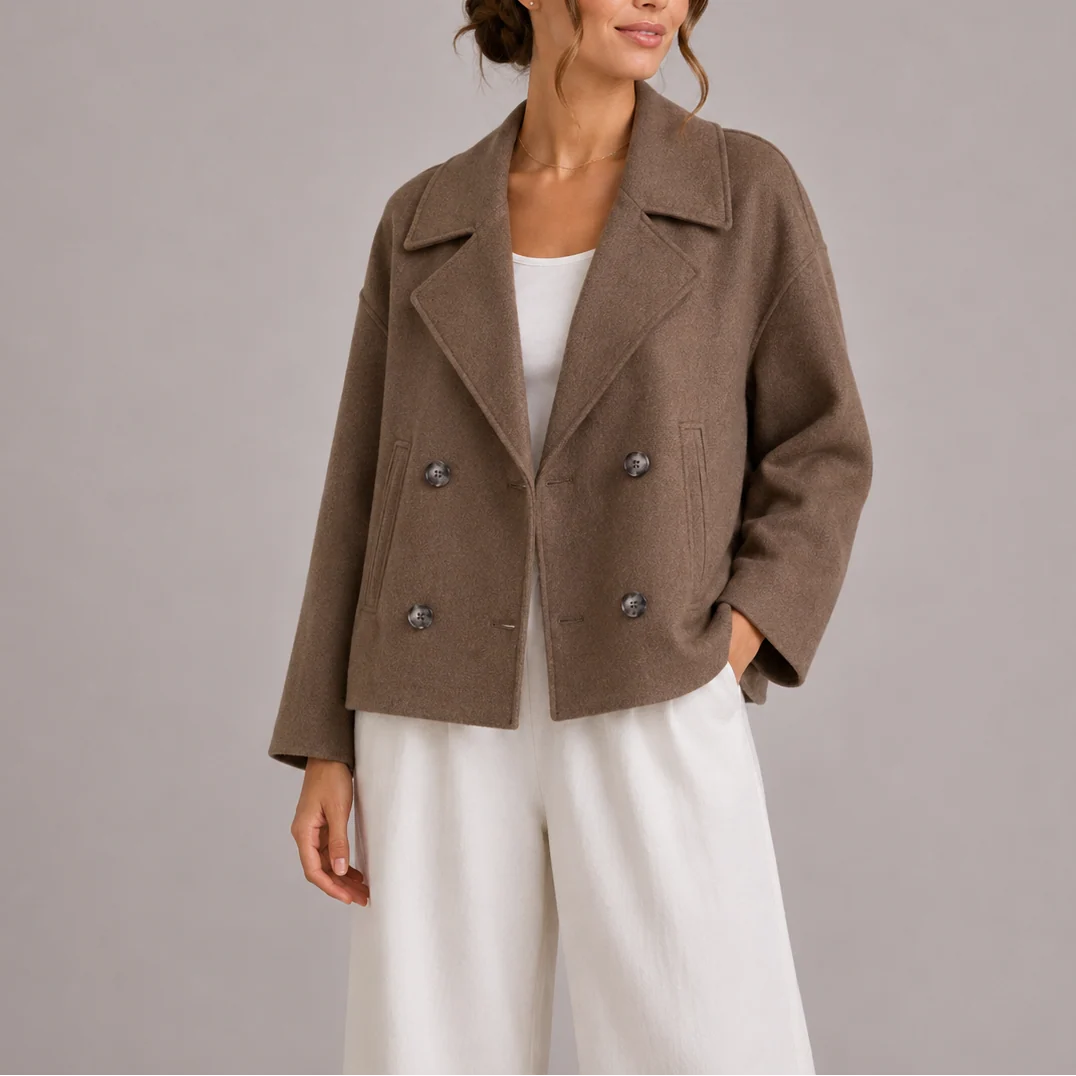 Side view of cropped double-breasted blazer highlighting relaxed shoulder line and hip-length cut