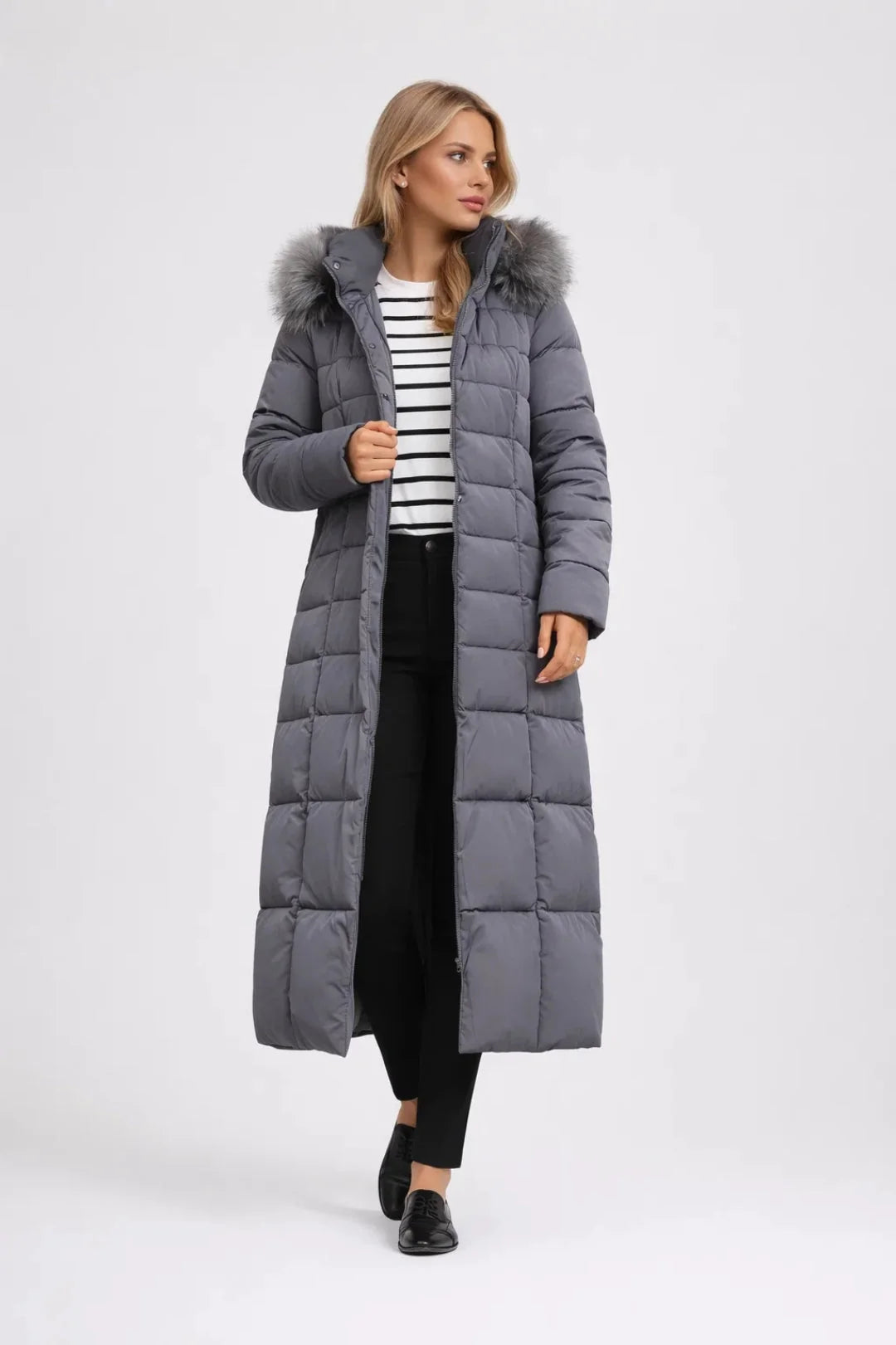 Close-up of women's long puffer coat featuring snap-button closure, faux fur hood trim, and side pockets
