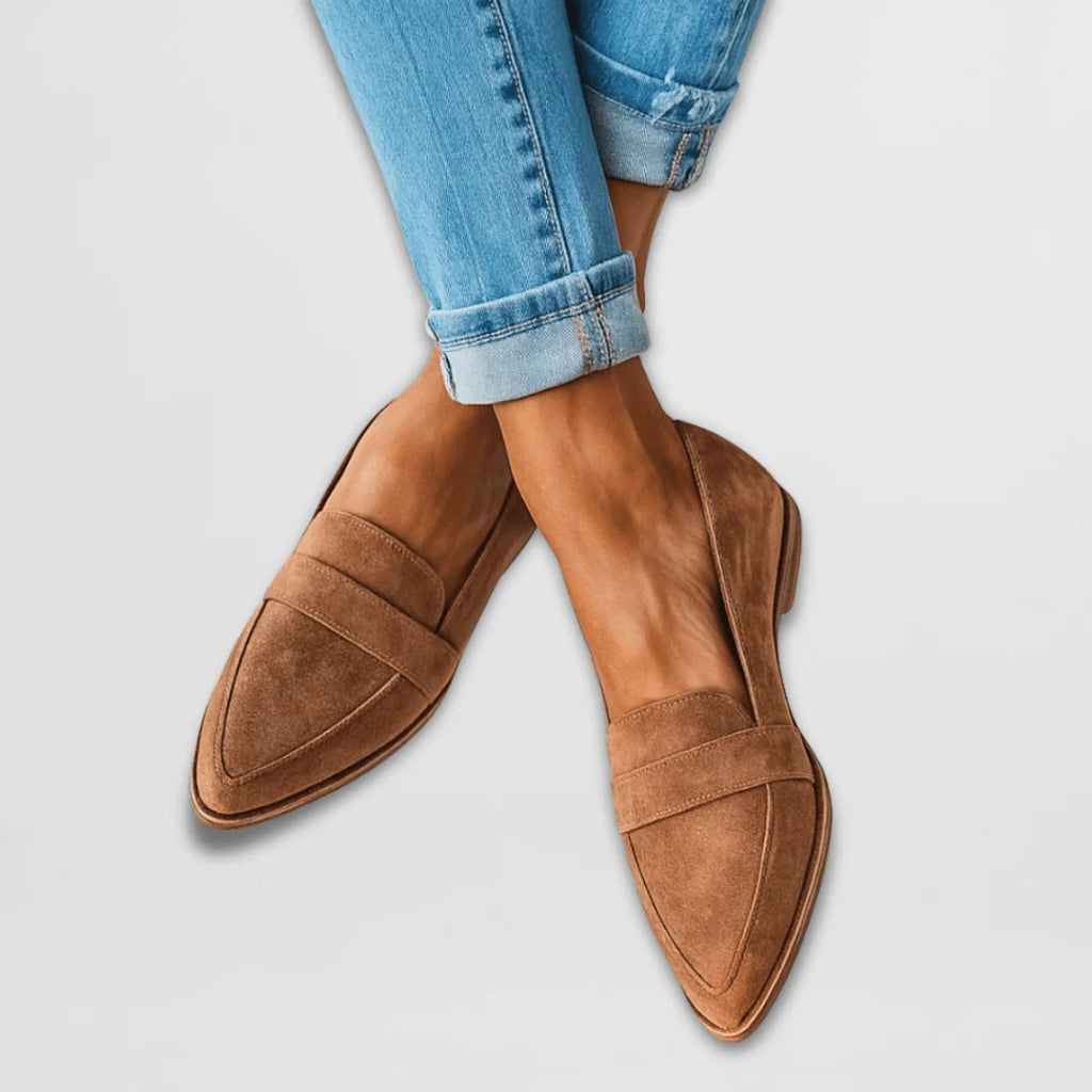 Women's suede loafers in tan with pointed toe and penny strap detail, styled with rolled-hem jeans