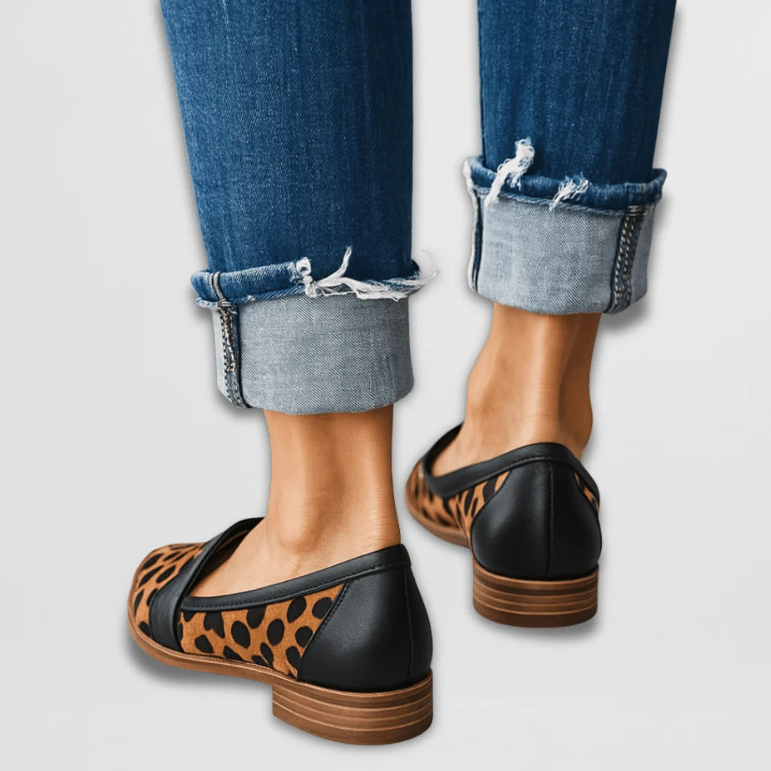 Detail shot of women's suede loafers featuring penny strap vamp and smooth suede texture