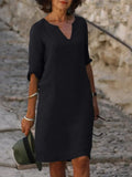 Woman wearing black v-neck midi dress with three-quarter sleeves and relaxed a-line fit on beach