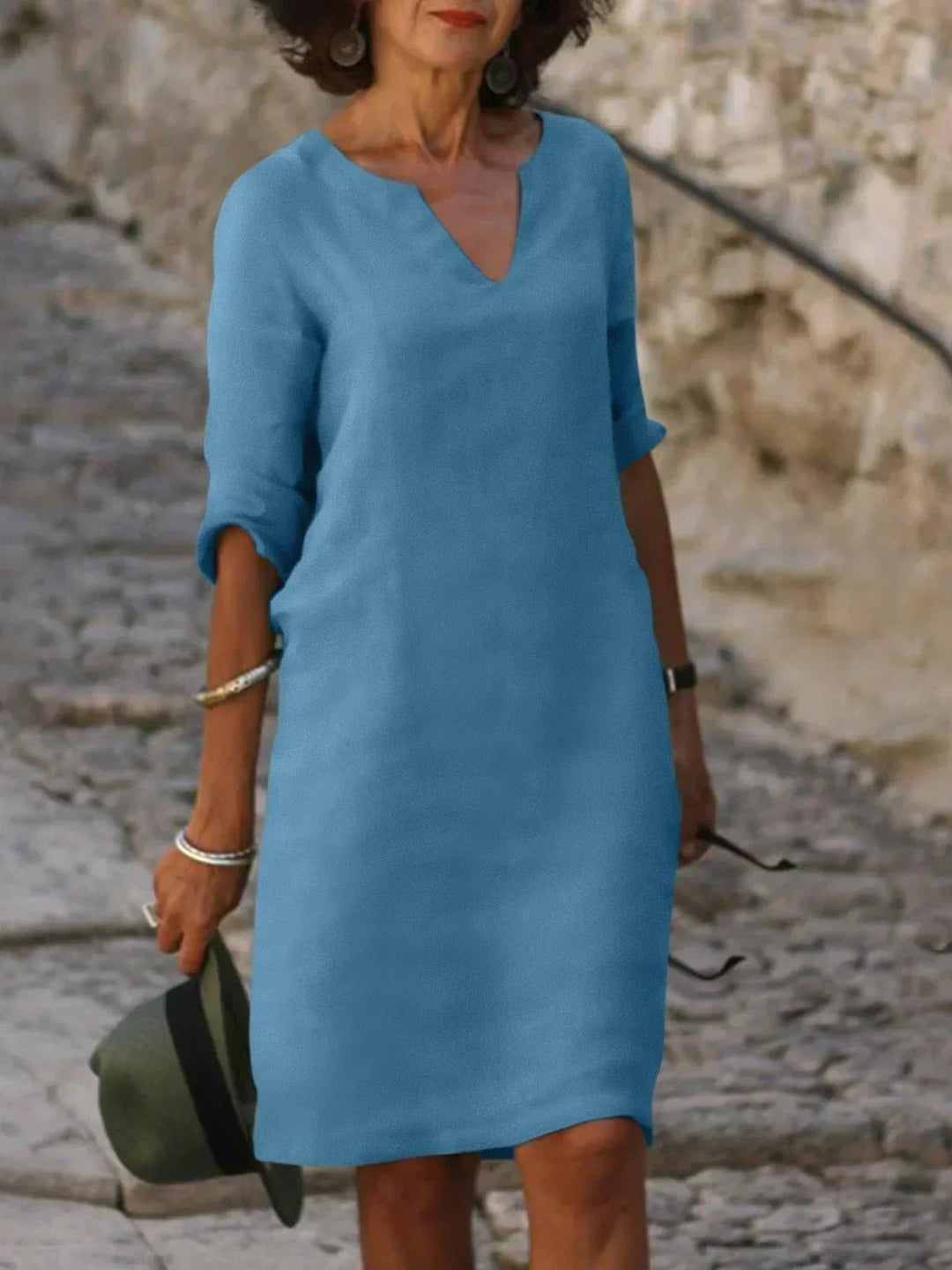 Woman in relaxed fit midi dress walking on beach showing movement and comfortable silhouette