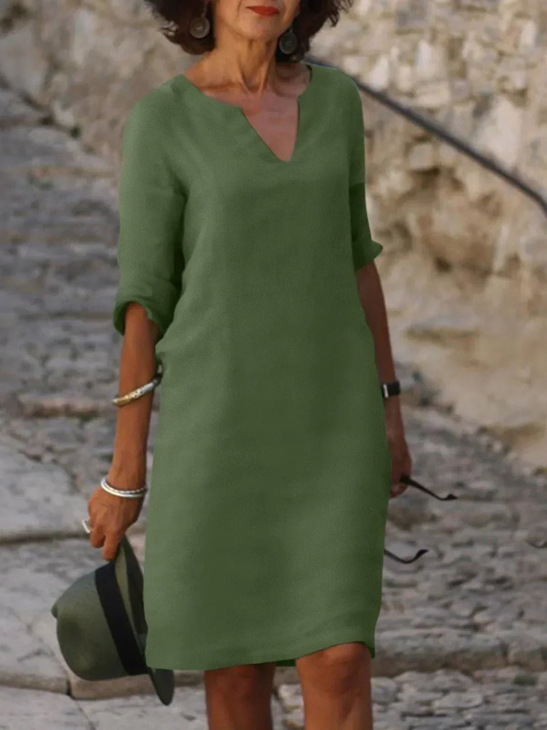 Side view of relaxed fit midi dress with knee-length hem and structured woven fabric drape