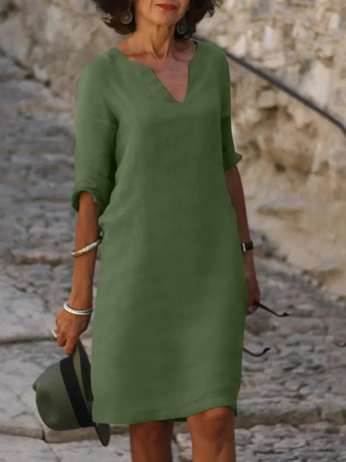 Side view of relaxed fit midi dress with knee-length hem and structured woven fabric drape