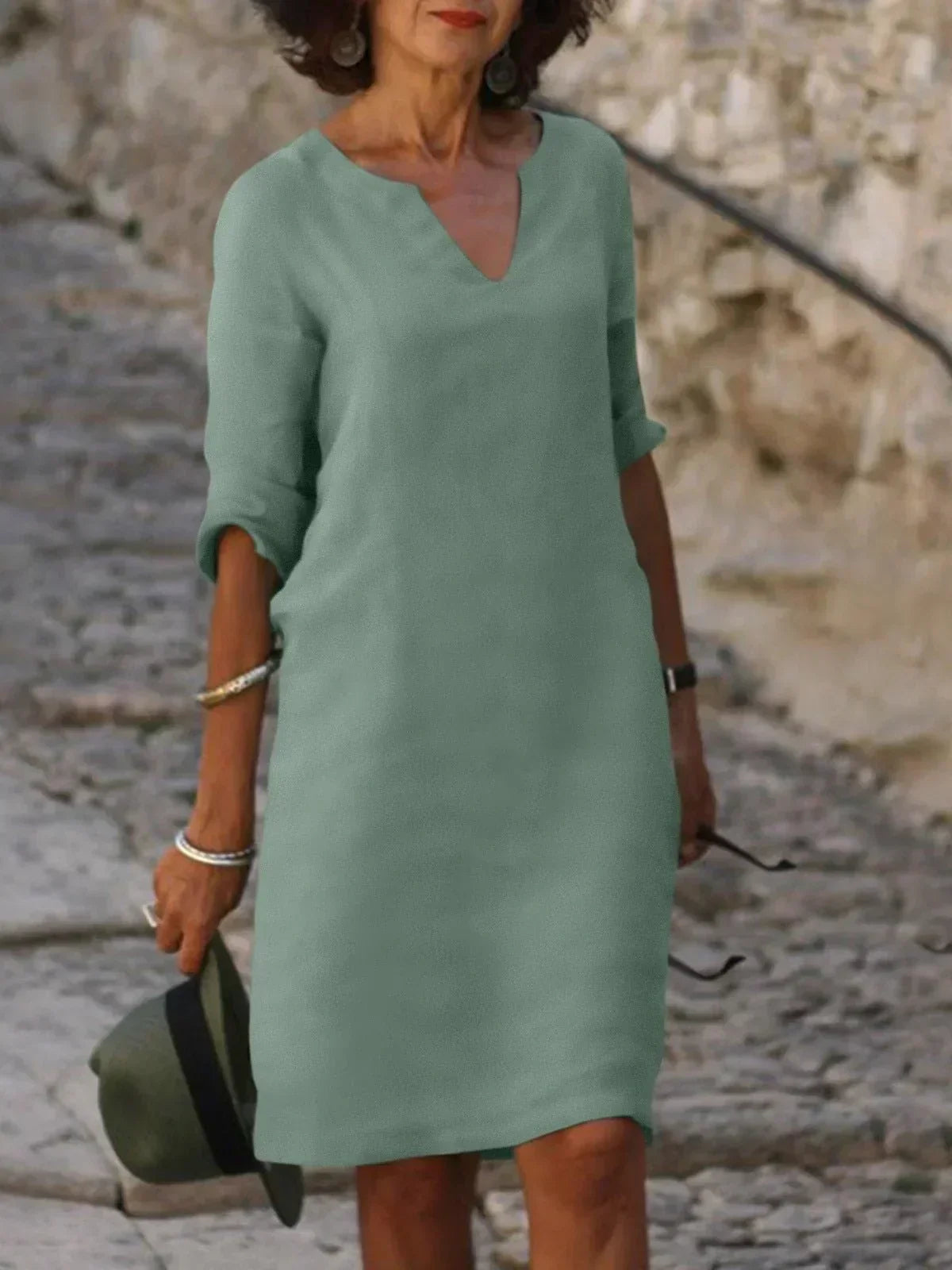 Woman in black midi dress with three-quarter sleeves styled casually for daytime wear outdoors