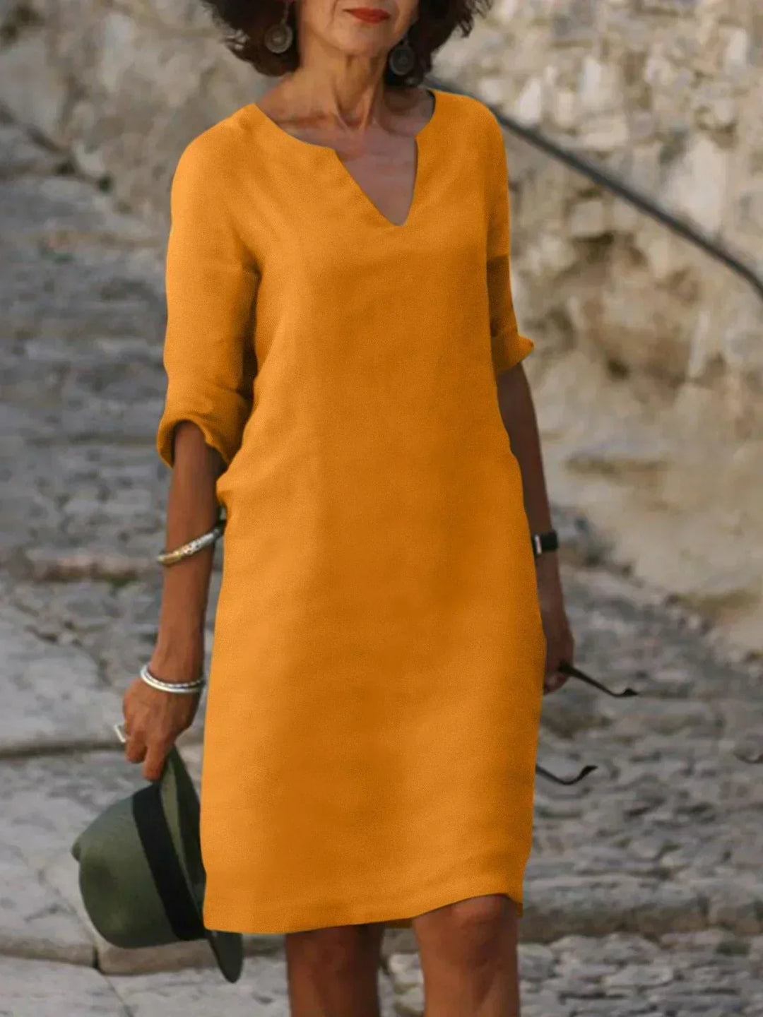Detail shot of v-neck midi dress showing smooth woven fabric texture and a-line silhouette