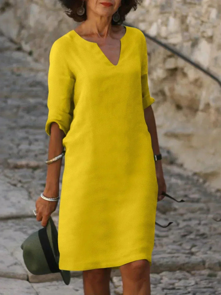 Full-length view of knee-length midi dress in black showing flattering a-line cut and drape