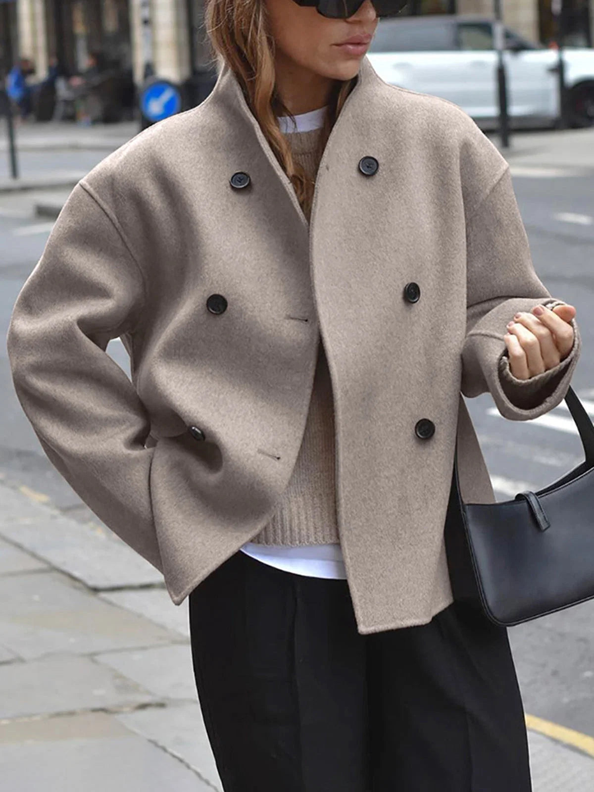 Women's double breasted pea coat in taupe with stand collar and relaxed fit worn outdoors