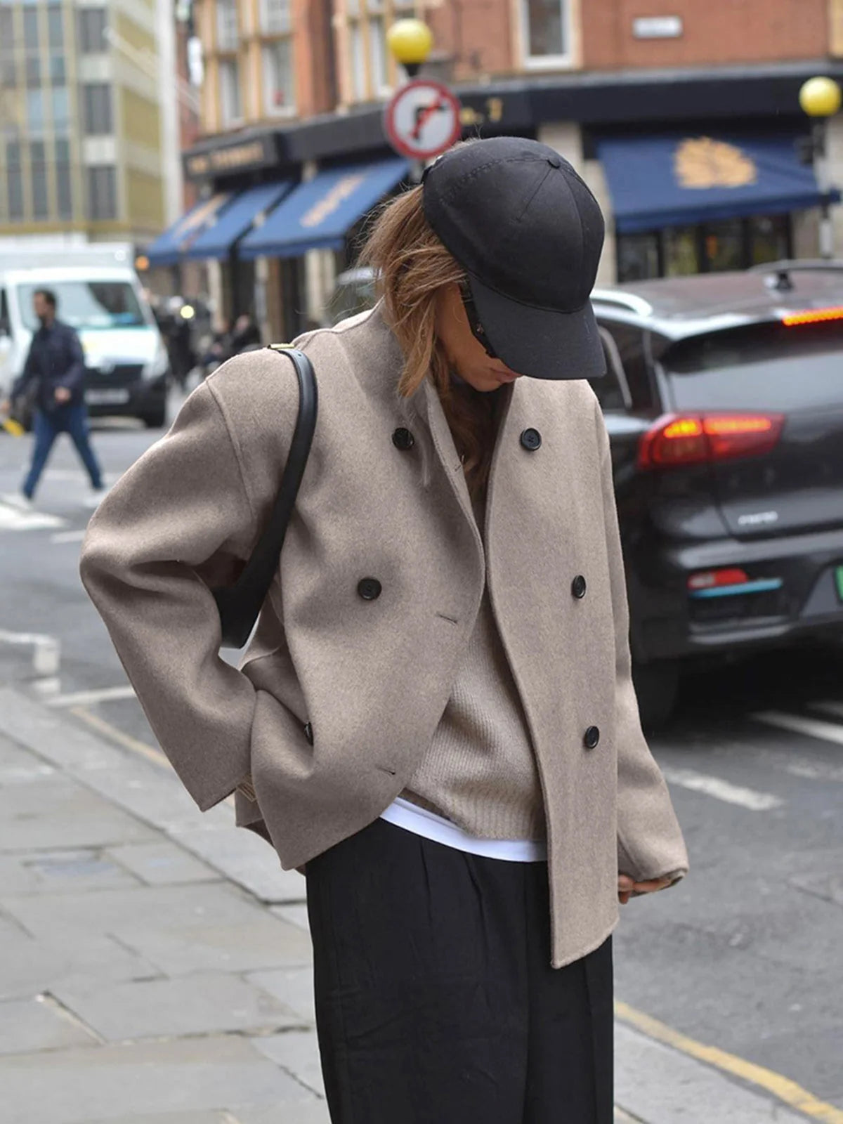 Close-up of double breasted button closure and stand collar detail on women's pea coat