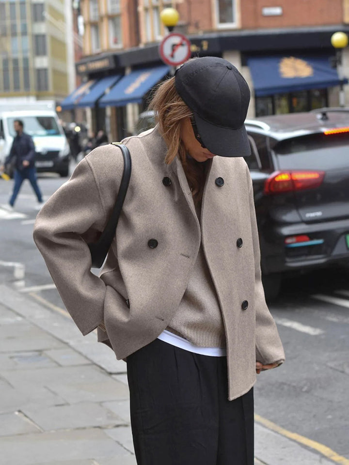 Close-up of double breasted button closure and stand collar detail on women's pea coat