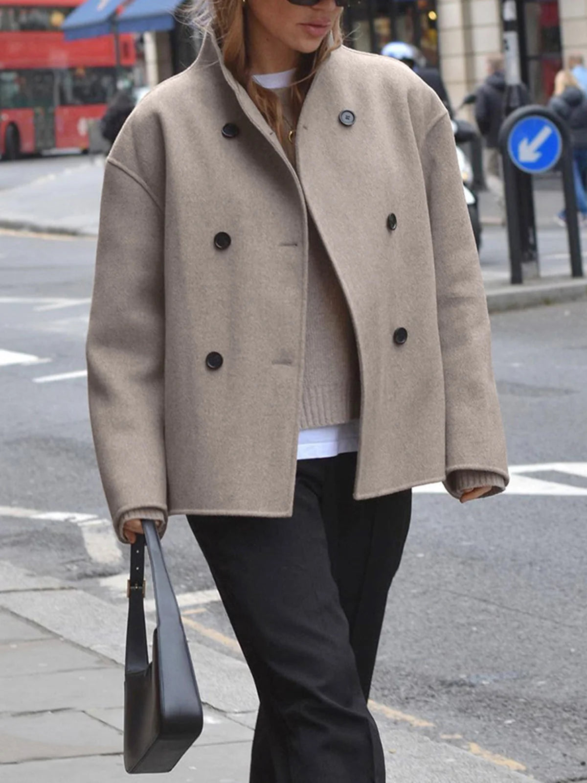 Women's pea coat in taupe styled with black trousers and layered knitwear