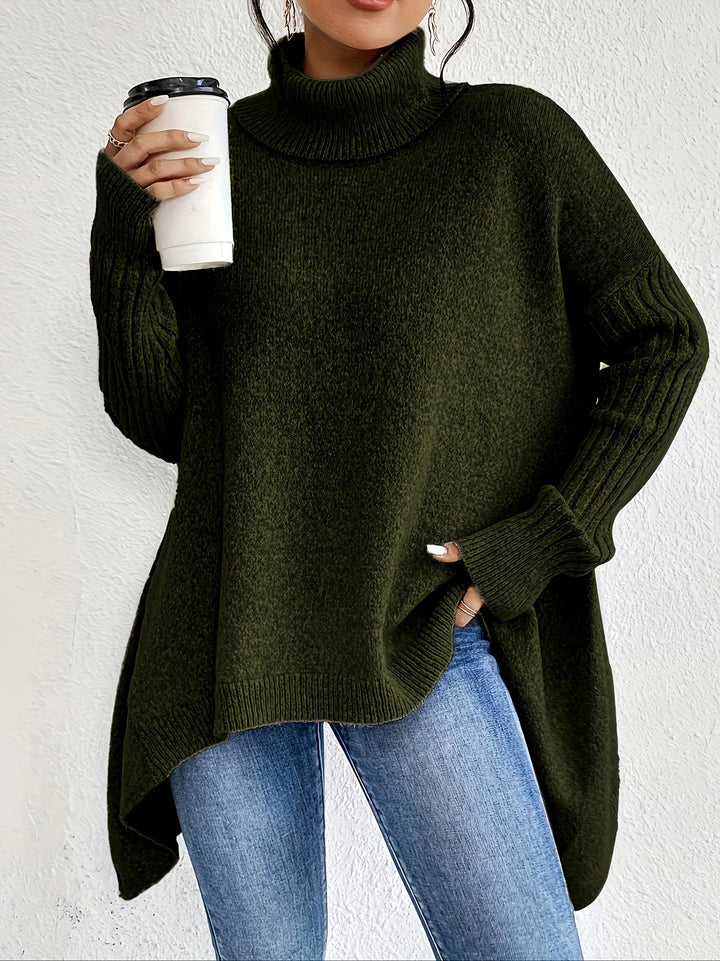 Woman wearing dark olive green oversized turtleneck jumper with relaxed fit and high-low hem paired with denim jeans